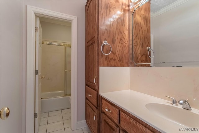 bathroom featuring vanity, ornamental molding, combined bath / shower with glass door, and tile patterned floors