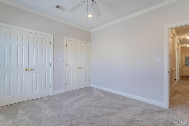 unfurnished bedroom with ornamental molding, carpet flooring, visible vents, and baseboards