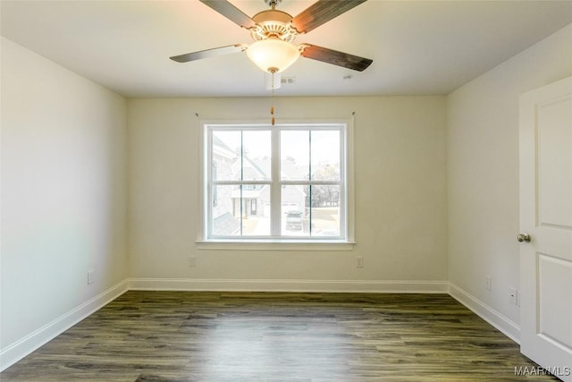 empty room with dark wood-style flooring, ceiling fan, and baseboards