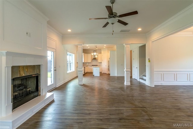 unfurnished living room with a decorative wall, a tiled fireplace, visible vents, and ornate columns