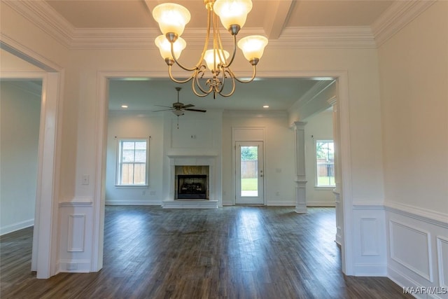 unfurnished living room featuring ornate columns, a fireplace with raised hearth, dark wood finished floors, and ceiling fan with notable chandelier