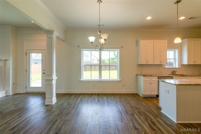 kitchen featuring decorative columns, decorative backsplash, ornamental molding, dark wood-style flooring, and white cabinetry