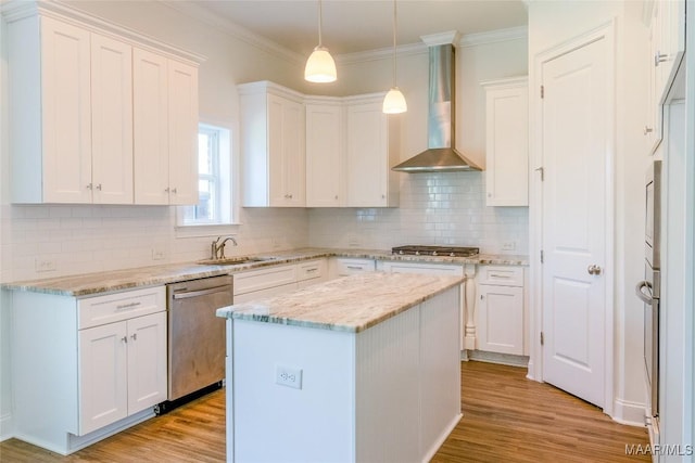 kitchen featuring stainless steel appliances, light wood-style flooring, white cabinets, a sink, and wall chimney exhaust hood