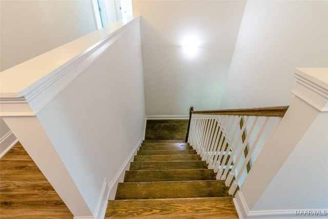 stairs with wood finished floors and baseboards