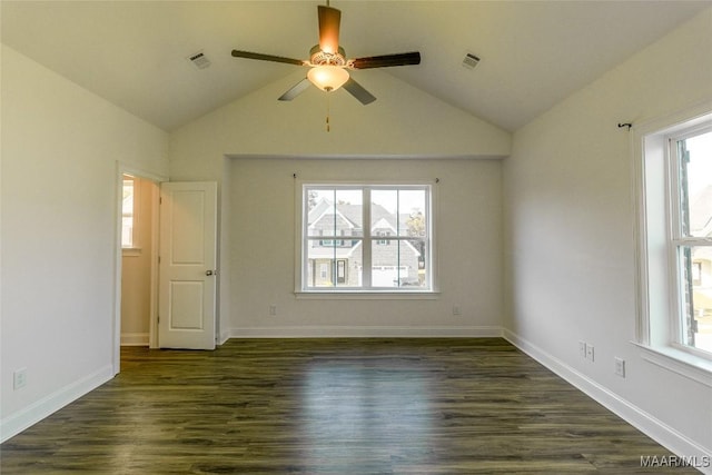 spare room with dark wood-style flooring, visible vents, and plenty of natural light