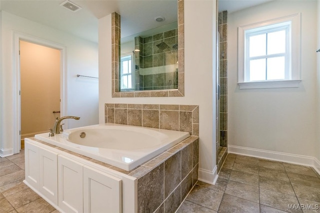 bathroom with a stall shower, a garden tub, and visible vents