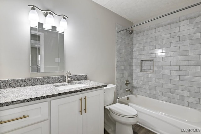 full bathroom featuring a textured ceiling, bathtub / shower combination, vanity, and toilet