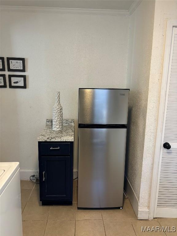 room details with ornamental molding, washer / clothes dryer, freestanding refrigerator, and baseboards