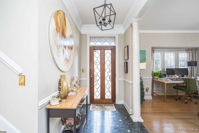 foyer entrance with a notable chandelier, dark wood-style flooring, baseboards, ornamental molding, and ornate columns