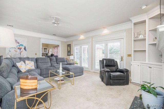 living room featuring ceiling fan, visible vents, crown molding, and light colored carpet