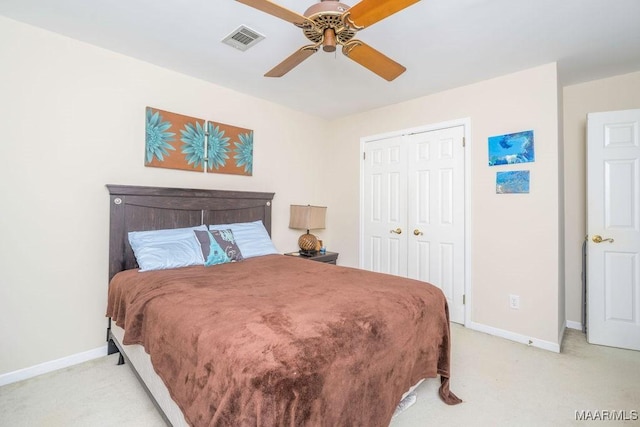 bedroom featuring ceiling fan, light carpet, visible vents, baseboards, and a closet