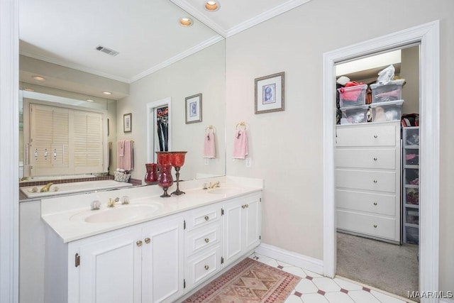 bathroom with crown molding, a walk in closet, visible vents, and a sink