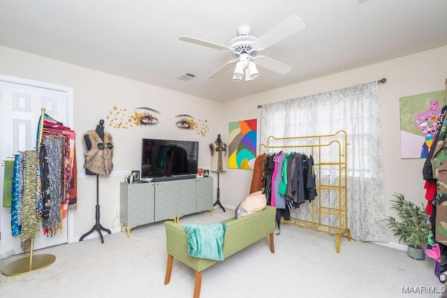 interior space with carpet floors, visible vents, and a ceiling fan