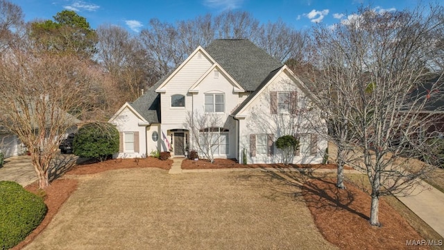 view of front of house featuring roof with shingles and a front lawn