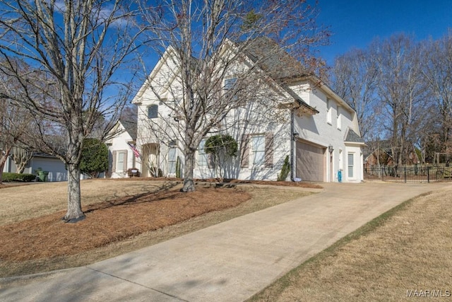 view of front of home featuring an attached garage, fence, and concrete driveway