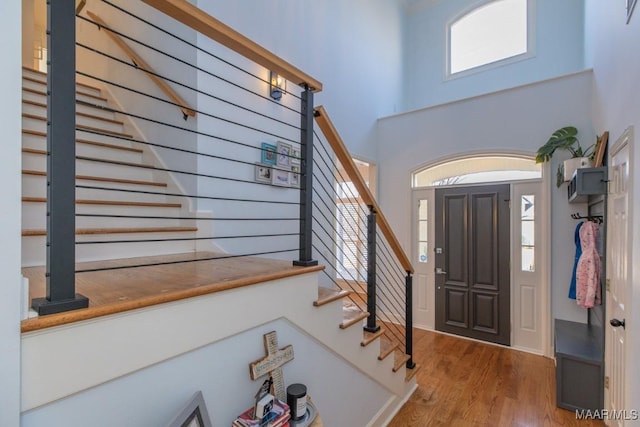 entryway featuring stairs, a high ceiling, and wood finished floors