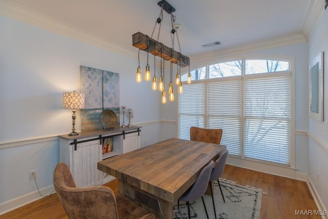 dining space with light wood-type flooring, baseboards, visible vents, and ornamental molding