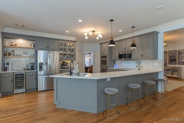 kitchen with wine cooler, appliances with stainless steel finishes, gray cabinets, and a sink