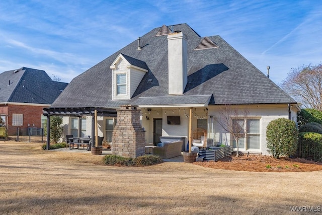 rear view of property featuring a patio area, a chimney, brick siding, and a yard