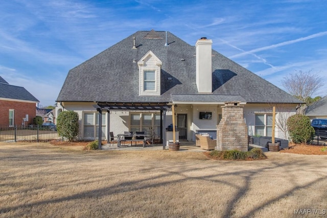 view of front facade with a chimney, fence, a front lawn, and a patio