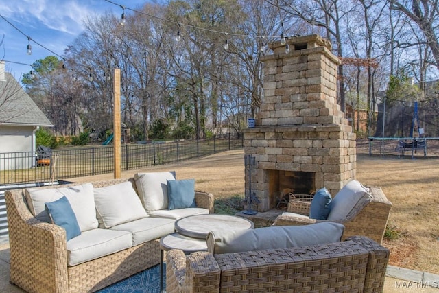 view of patio / terrace featuring an outdoor living space with a fireplace, a trampoline, and a fenced backyard