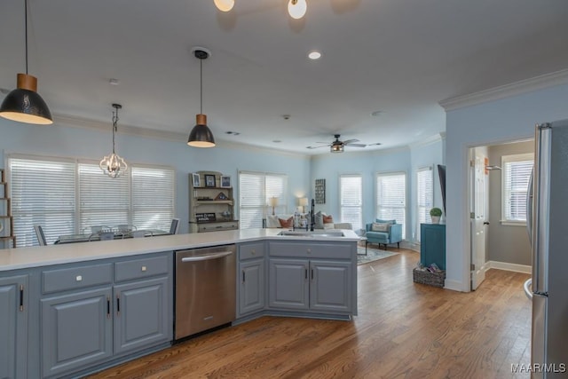 kitchen with a ceiling fan, wood finished floors, gray cabinets, crown molding, and stainless steel appliances