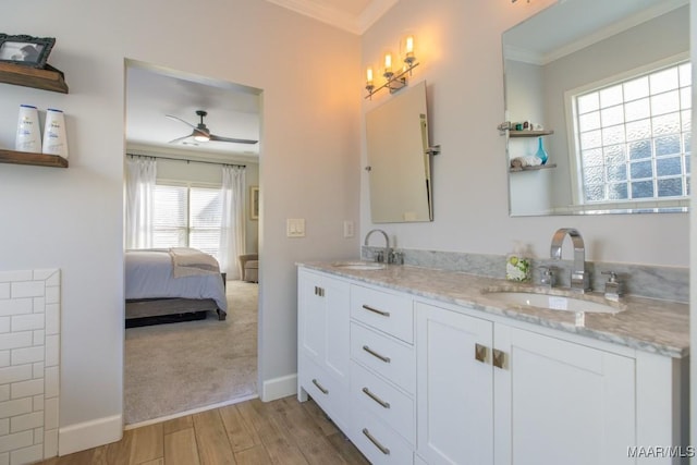 full bathroom featuring double vanity, a sink, a ceiling fan, and crown molding