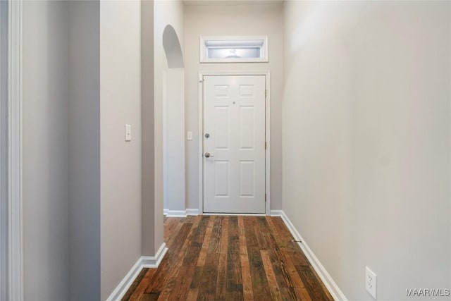 entryway with dark wood-style floors, baseboards, and arched walkways