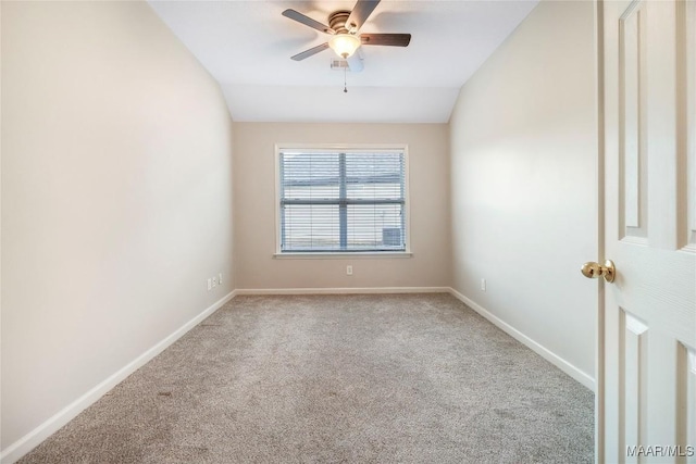 carpeted empty room featuring vaulted ceiling, ceiling fan, and baseboards