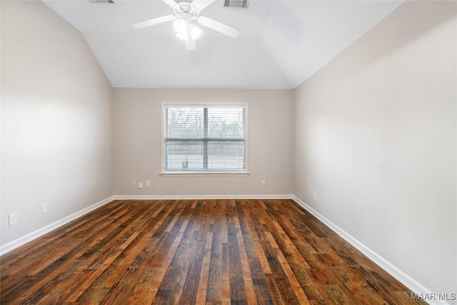 spare room with dark wood finished floors, visible vents, a ceiling fan, vaulted ceiling, and baseboards