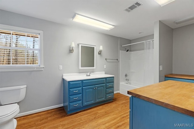 full bath with visible vents, toilet, vanity, wood finished floors, and baseboards