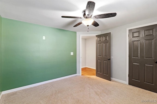 unfurnished bedroom featuring ceiling fan, carpet, and baseboards