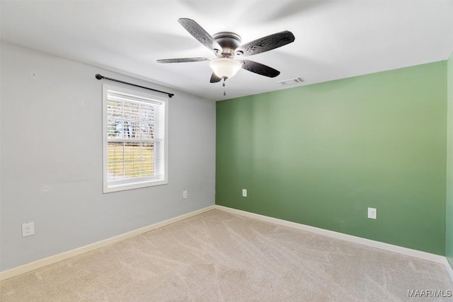 empty room featuring a ceiling fan, baseboards, visible vents, and carpet flooring