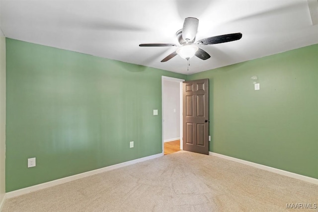 spare room featuring a ceiling fan, carpet flooring, and baseboards