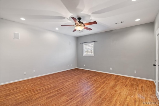 unfurnished room with light wood finished floors, visible vents, and baseboards