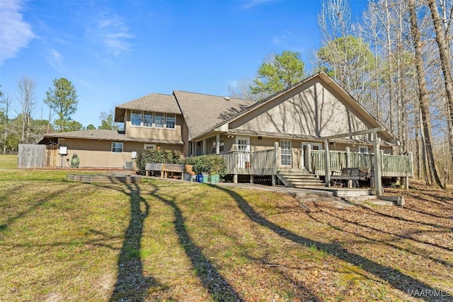 back of property with a lawn and a wooden deck