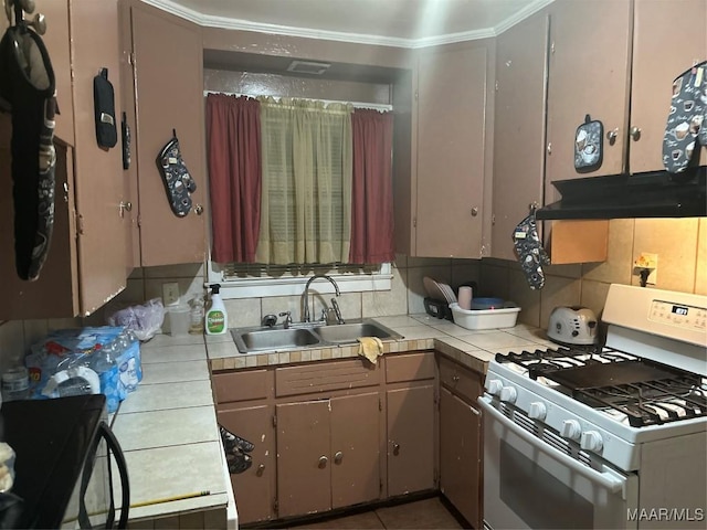 kitchen featuring tasteful backsplash, a sink, tile countertops, and white gas range