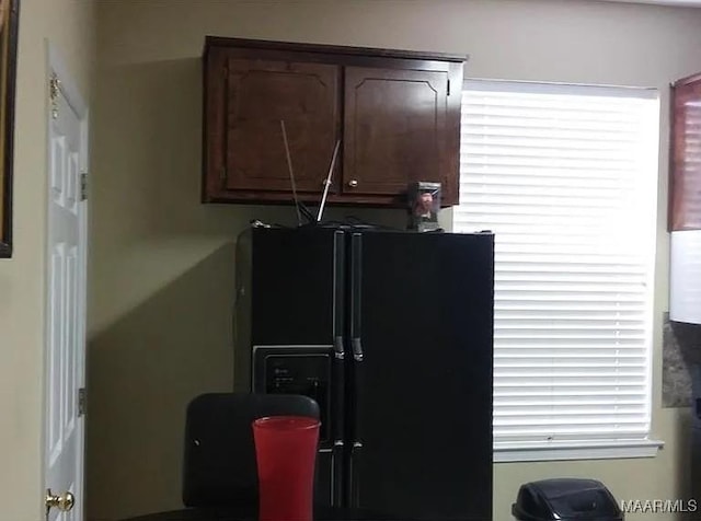 kitchen with black fridge with ice dispenser