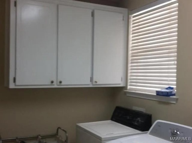 laundry room with washing machine and clothes dryer and cabinet space