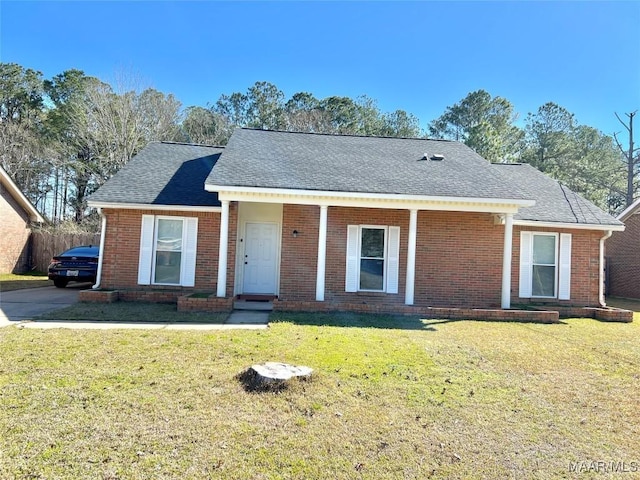 single story home featuring brick siding, a front lawn, and roof with shingles