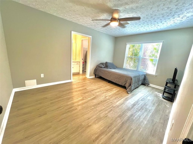 bedroom with baseboards, ceiling fan, a textured ceiling, and light wood-style floors