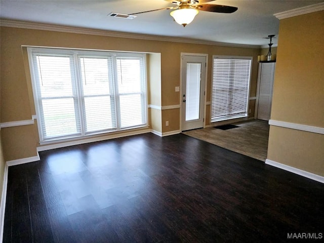 interior space with ornamental molding, visible vents, dark wood finished floors, and baseboards