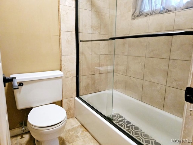 full bath with tile patterned flooring, combined bath / shower with glass door, and toilet