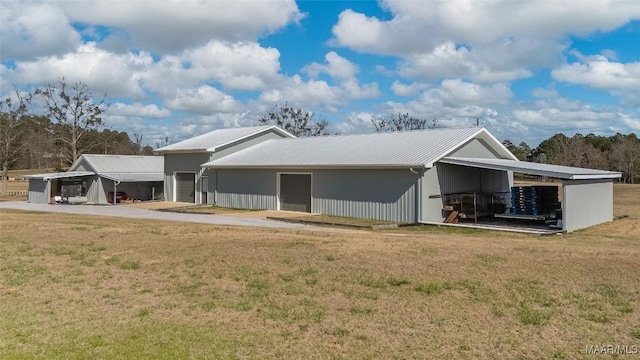 9524 County Road 42nd Rd, Jemison, AL 35085 - rear view of house with a pole building, a detached garage, an outbuilding, a lawn, and metal roof