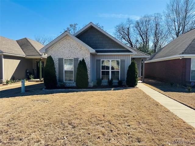 view of front of property featuring board and batten siding, brick siding, and a front lawn