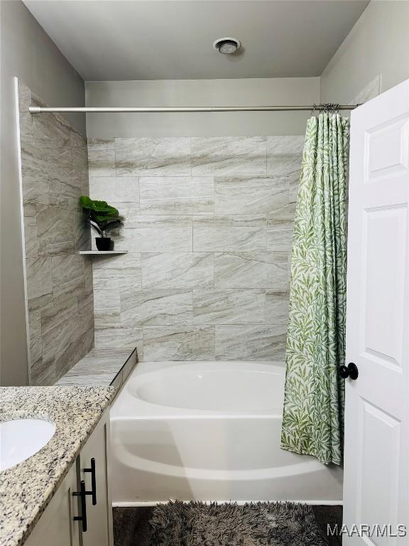 bathroom featuring shower / bath combo with shower curtain and vanity