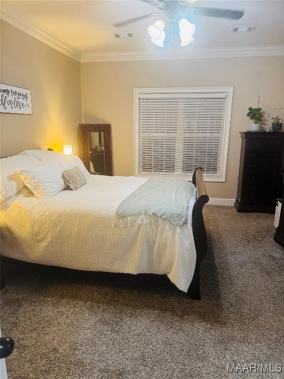 bedroom with ornamental molding, visible vents, ceiling fan, and carpet flooring