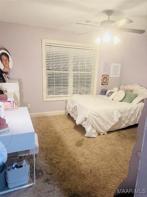 carpeted bedroom with ceiling fan and baseboards