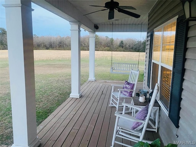 wooden deck with ceiling fan and a yard