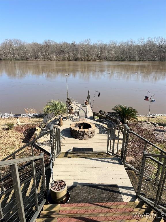 dock area with an outdoor fire pit and a water view